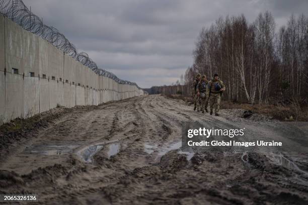 Ukrainian border guards walk past concrete barrier during patrolling of the border with Belarus on February 13, 2024 in Volyn Oblast, Ukraine....