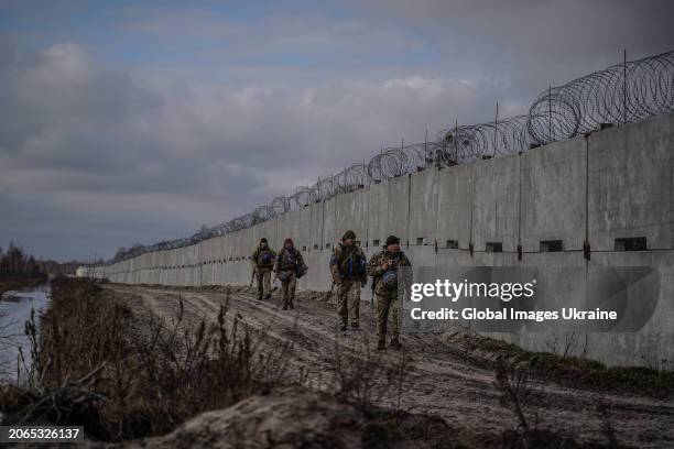 Ukrainian border guards walk past concrete barrier during patrolling of the border with Belarus on February 13, 2024 in Volyn Oblast, Ukraine....