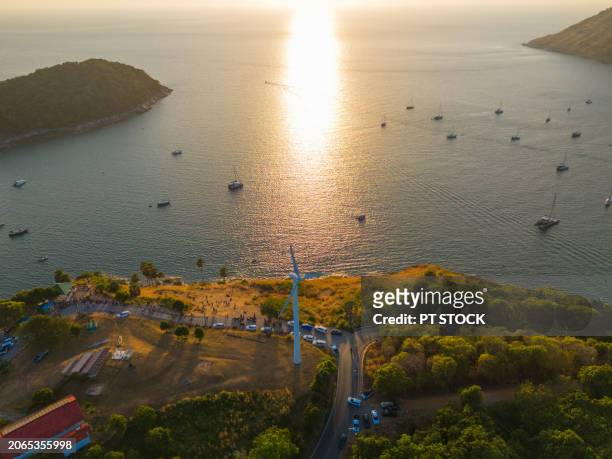 aerial view drone windmill on the hill and many ships in the sea have golden fields during the golden hour near sunset. - sunset cliffs stage stock pictures, royalty-free photos & images