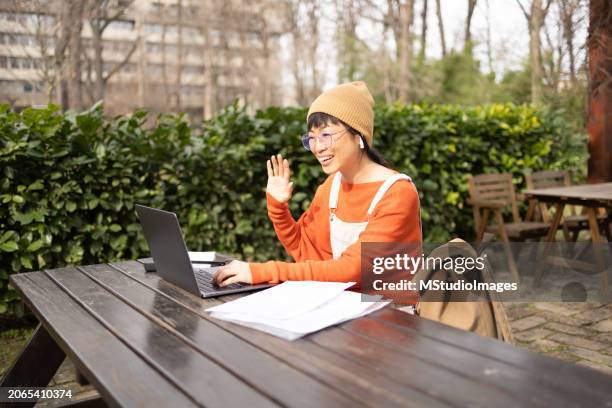 asian woman remote working from the park - video conference stock pictures, royalty-free photos & images