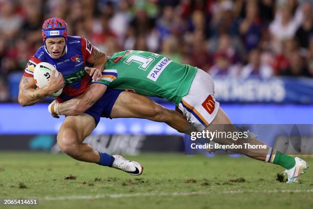 Kalyn Ponga of the Knights is tackled by Hudson Young of the Raiders during the round one NRL match between Newcastle Knights and Canberra Raiders at...