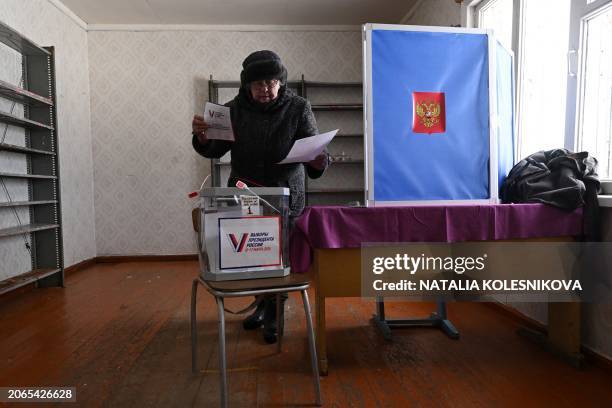 Woman votes at a polling station during early voting for Russia's presidential election in the village of Sennaya Guba, Republic of Karelia, on March...