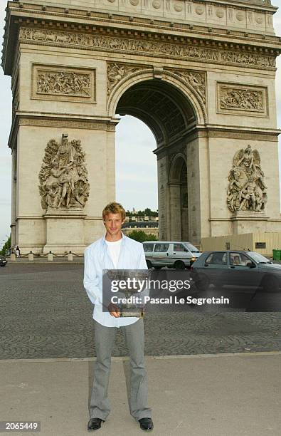 Juan Carlos Ferrero of Spain poses with the trophy with the Arc de Triomphe in the backgroung after winning his mens final match against Martin...