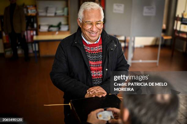 Outgoing Portuguese Prime Minister Antonio Costa shows his national identity card before casting his ballot at a polling station in Benfica, Lisbon,...