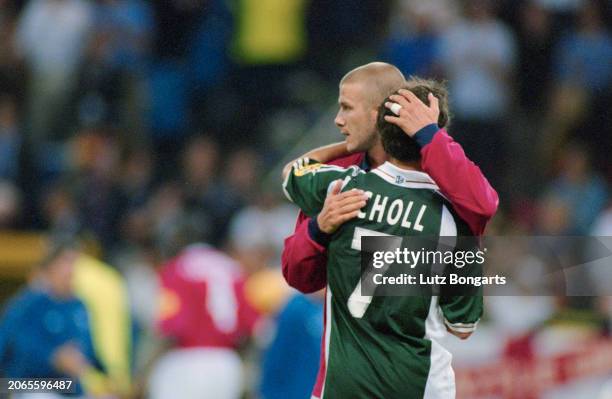 British footballer David Beckham embraces German footballer Mehmet Scholl during the UEFA Euro 2000 Group A match between England and Germany, held...