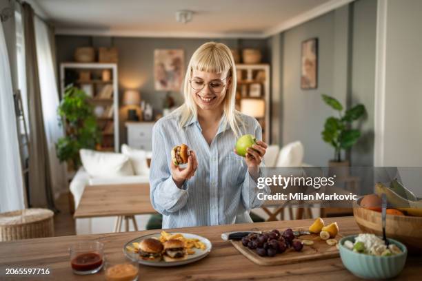 what to eat, a tasty burger or a healthy apple - cholesterol stockfoto's en -beelden