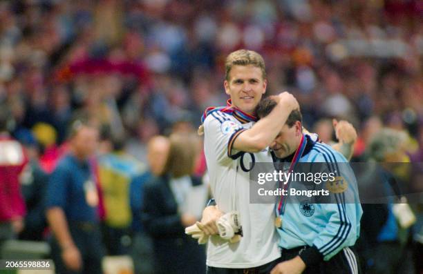 German footballer Oliver Bierhoff embraces German footballer Andreas Kopke, each wearing their winners' medal, after the UEFA Euro 1996 final between...