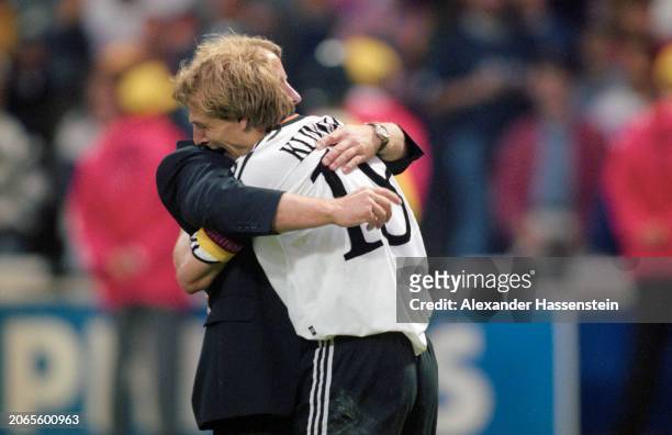 German football manager Berti Vogts embraces German footballer Jürgen Klinsmann after the UEFA Euro 1996 final between the Czech Republic and...