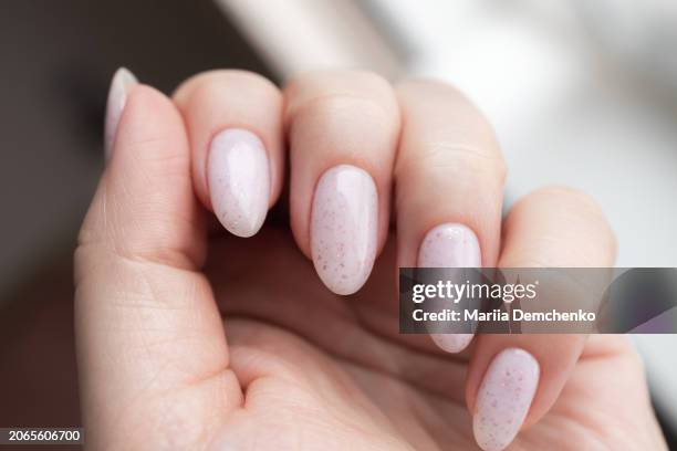 hand with beautiful manicure - pink gel nails with glitter - manicure stockfoto's en -beelden