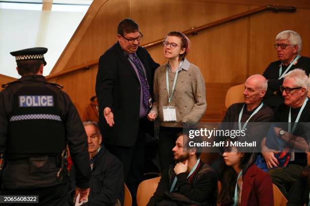 Protestor from This Is Rigged is led away from the chamber during First Minister's Questions at Scottish Parliament at Scottish Parliament Building...