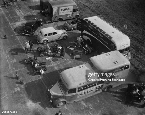 High angle view of mechanics, racing cars and other vehicles in the pits before the British Grand Prix at Silverstone Circuit, Northamptonshire, July...