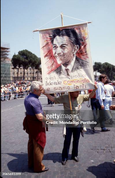 Militants during the funeral of the Secretary of the Italian Communist Party, Enrico Berlinguer in Piazza San Giovanni wave as the coffin passes....