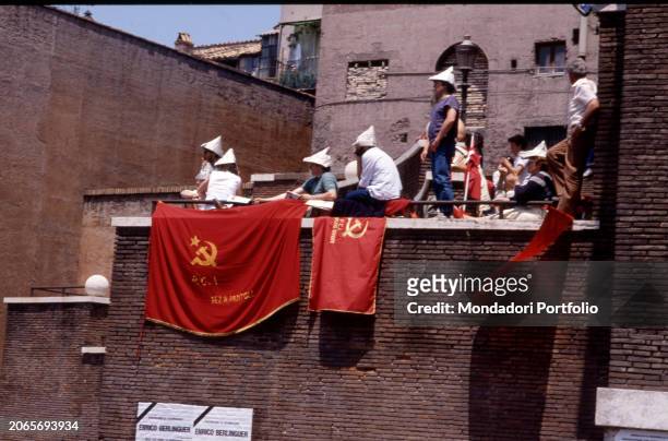Militants during the funeral of the Secretary of the Italian Communist Party, Enrico Berlinguer in Piazza San Giovanni wave as the coffin passes....