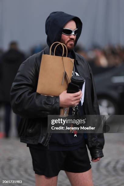 Fashion Week guest is seen wearing black shorts, black pullover, silver Balenciaga shades and a black leather jacket outside before the Balenciaga...