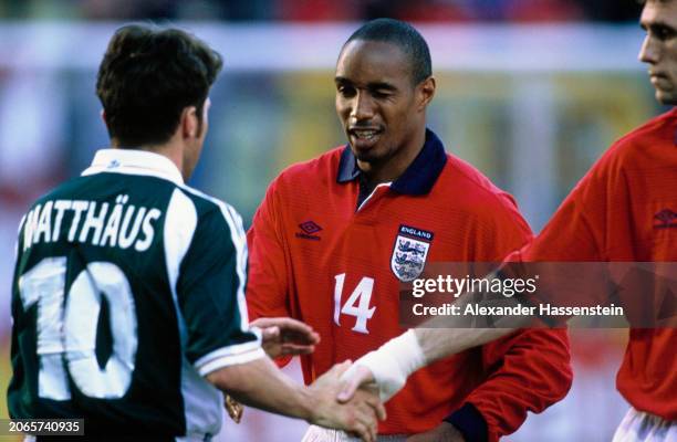 German footballer Lothar Matthäus shakes hands with British footballer Martin Keown while speaking with British footballer Paul Ince after the UEFA...