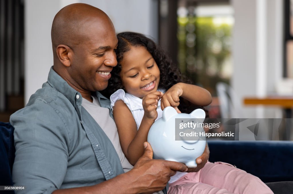 Père et fille économisant de l’argent dans une tirelire