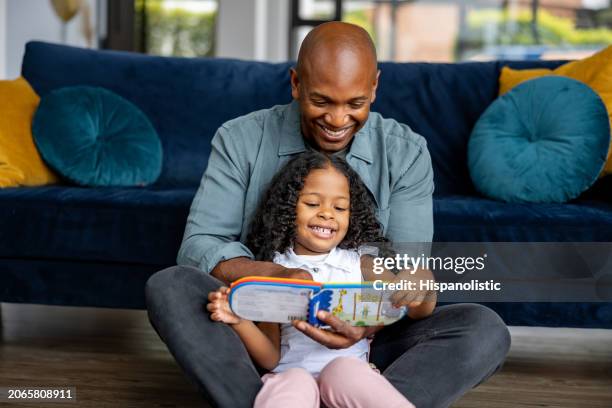 loving father reading a book to his daughter - child reading book stock pictures, royalty-free photos & images