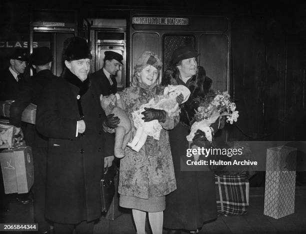 Swedish actress and singer Tatiana Angelini , with her mother and father, holding a doll and a teddy bear on arrival at St Pancras Station in London,...