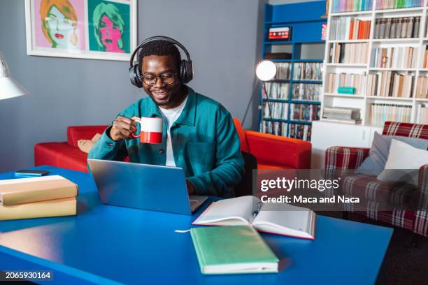 hombre afroamericano sentado en el escritorio y usando una computadora portátil - vida sencilla fotografías e imágenes de stock