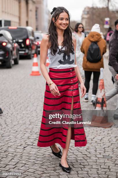 Kelsey Merritt wears black and white striped Chanel top, black and red striped long skirt, black Chanel ballet flats, outside Chanel, during the...