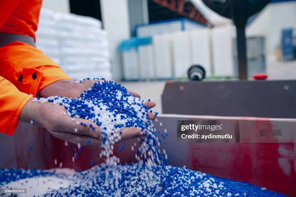 I granuli di plastica vengono versati dalla mano