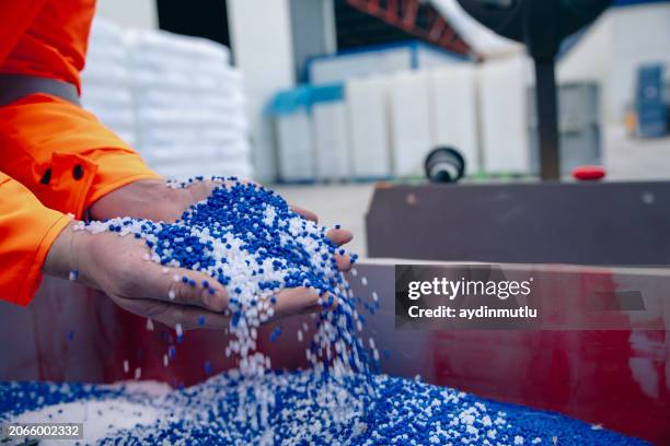 plastic granules are poured from the hand - material palette stock pictures, royalty-free photos & images