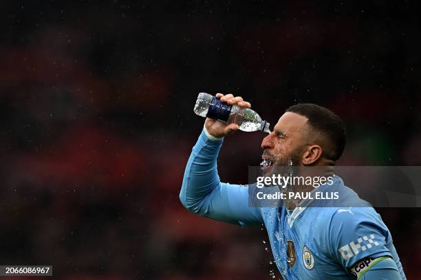 Manchester City's English defender Kyle Walker pours water over his face before spitting it out, ahead of the English Premier League football match...