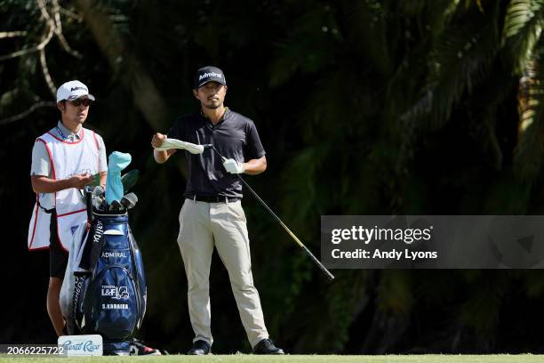 Satoshi Kodaira of Japan waits with his caddie before playing his shot from the fourth tee during the first round of the Puerto Rico Open at Grand...