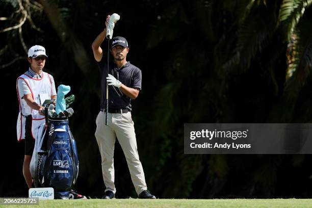 Satoshi Kodaira of Japan waits with his caddie before playing his shot from the fourth tee during the first round of the Puerto Rico Open at Grand...