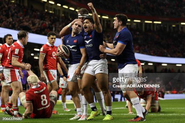 France's Maxime Lucu celebrates with teammates after scoring their fifth try during the Six Nations international rugby union match between Wales and...