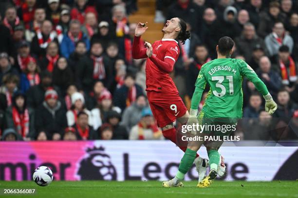 Manchester City's Brazilian goalkeeper Ederson fouls Liverpool's Uruguayan striker Darwin Nunez to concede a penalty during the English Premier...