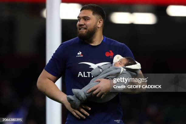 France's lock Emmanuel Meafou celebrates with his baby on the pitch after the Six Nations international rugby union match between Wales and France at...