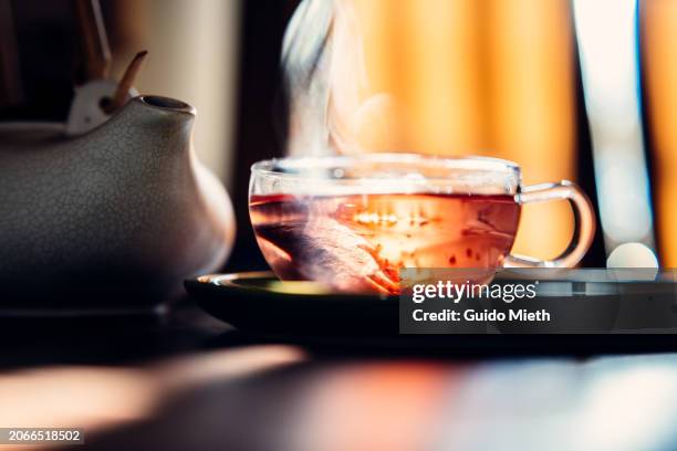 glass of tea beside on a green plate. - chamomile tea bag stock pictures, royalty-free photos & images