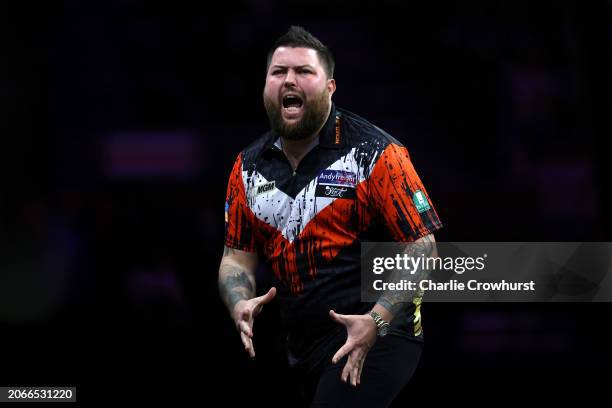 Michael Smith of England reacts after missing a winning dart during his Quarter-Final match against Peter Wright of Scotland at the 2024 BetMGM...