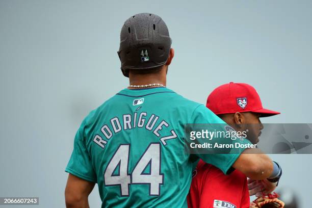 Julio Rodriguez of the Seattle Mariners hugs Luis Rengifo of the Los Angeles Angels during a stop in play in the first inning during a spring...