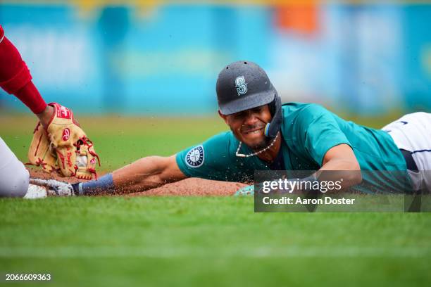 Julio Rodriguez of the Seattle Mariners dives back into third base safely ahead of the tag from Luis Rengifo of the Los Angeles Angels in the first...