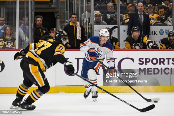 Edmonton Oilers center Ryan McLeod passes the puck as Pittsburgh Penguins defenseman Ryan Graves defends during the first period in the NHL game...