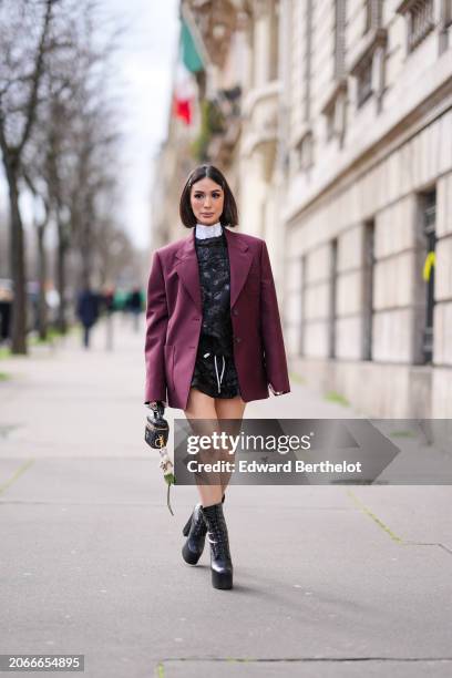 Heart Evangelista wears hair pins, a white shirt, a burgundy oversized blazer jacket , a black floral print mini dress , a black leather bag , high...