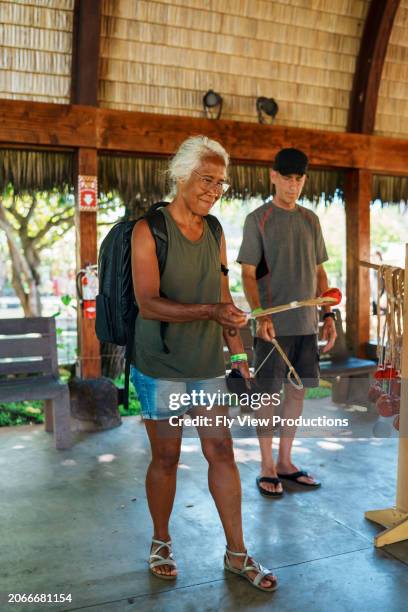 senior couple shopping for souvenirs while on tropical vacation - hawaii souvenir stock pictures, royalty-free photos & images