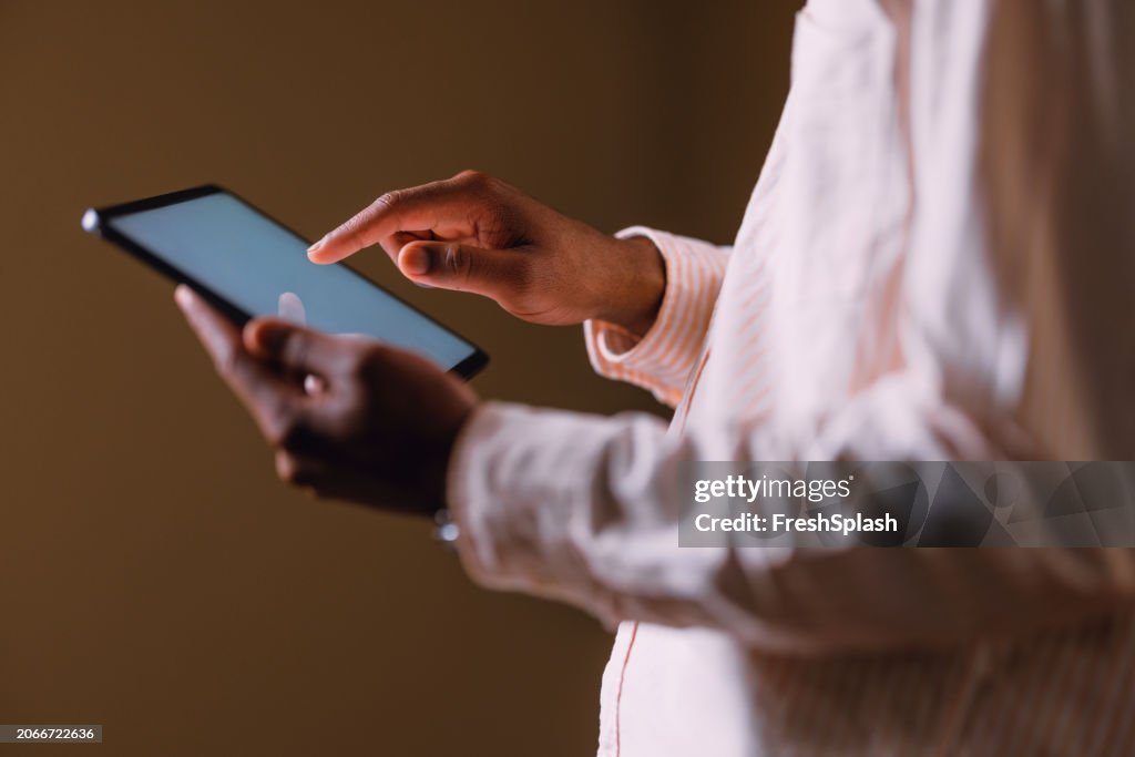 Close-up of Hands Using Digital Tablet on Dark Background