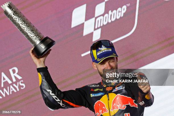 Second placed Red Bull KTM Factory Racing South African rider Brad Binder celebrates with the trophy during the podium ceremony of the Qatar MotoGP...