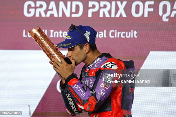 Third placed Prima Pramac Racing Spanish rider Jorge Martin kisses his trophy during the podium ceremony of the Qatar MotoGP Grand Prix at the Lusail...