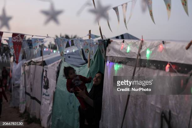 Palestinians are taking refuge in Deir al-Balah, in the central Gaza Strip, and are decorating their tents with Ramadan lanterns and illuminating...