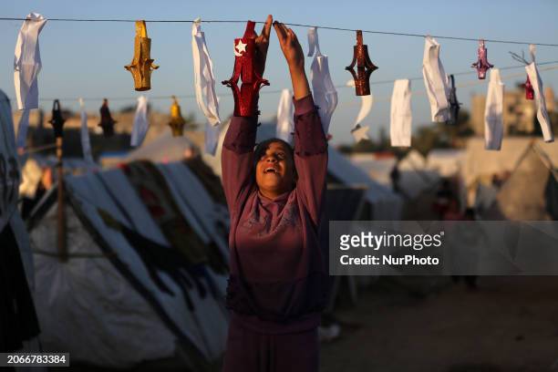 Palestinians are taking refuge in Deir al-Balah, in the central Gaza Strip, and are decorating their tents with Ramadan lanterns and illuminating...