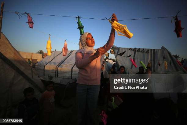 Palestinians are taking refuge in Deir al-Balah, in the central Gaza Strip, and are decorating their tents with Ramadan lanterns and illuminating...