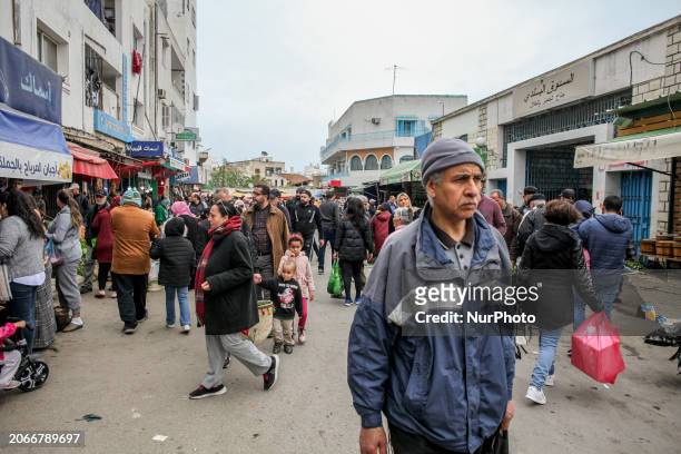 Tunisian customers are holding bags as they walk through the market in the Ariana district in Tunis, Tunisia, on March 10, 2024. Tunisia is being hit...