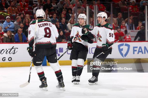 Clayton Keller and Sean Durzi of the Arizona Coyotes celebrate with teammates after Keller scores against the Chicago Blackhawks in the first period...
