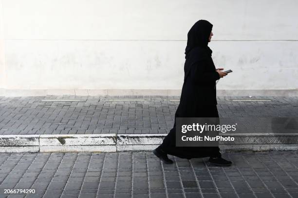 Woman wearing burqa walks the street in Manama, Bahrain on March 4, 2024.