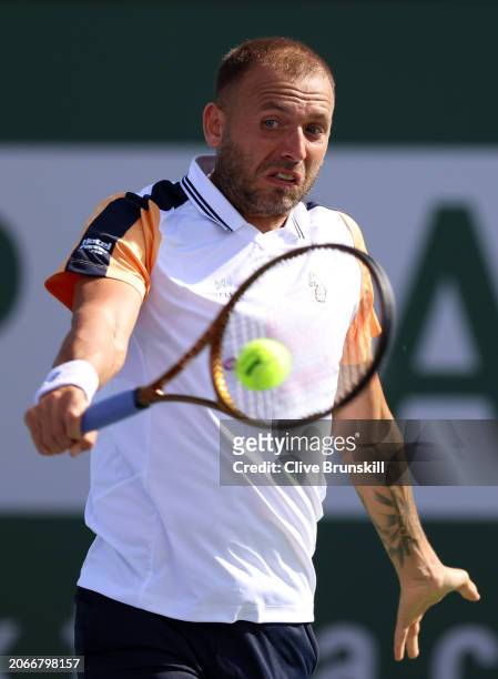 Dan Evans of Great Britain plays a backhand against Roman Safiullin in their first round match during the BNP Paribas Open at Indian Wells Tennis...