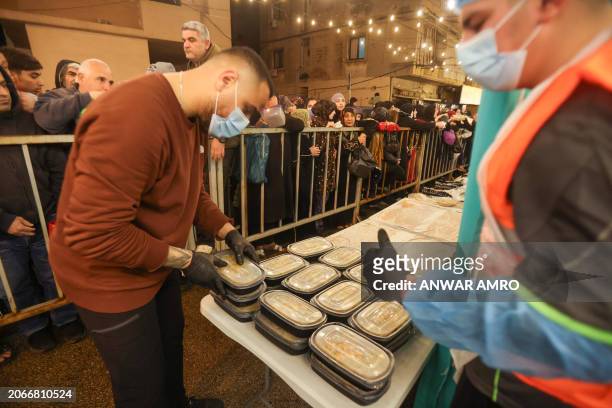 Volunteers prepare to distribute food for suhoor, the pre-fasting meal during the Muslim holy month of Ramadan, when observant devotees refrain from...